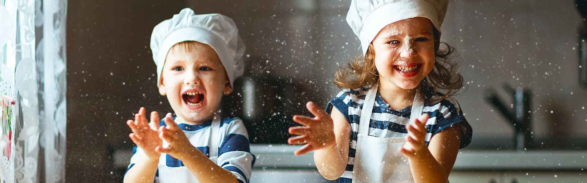 Two children cooking with chef hats on