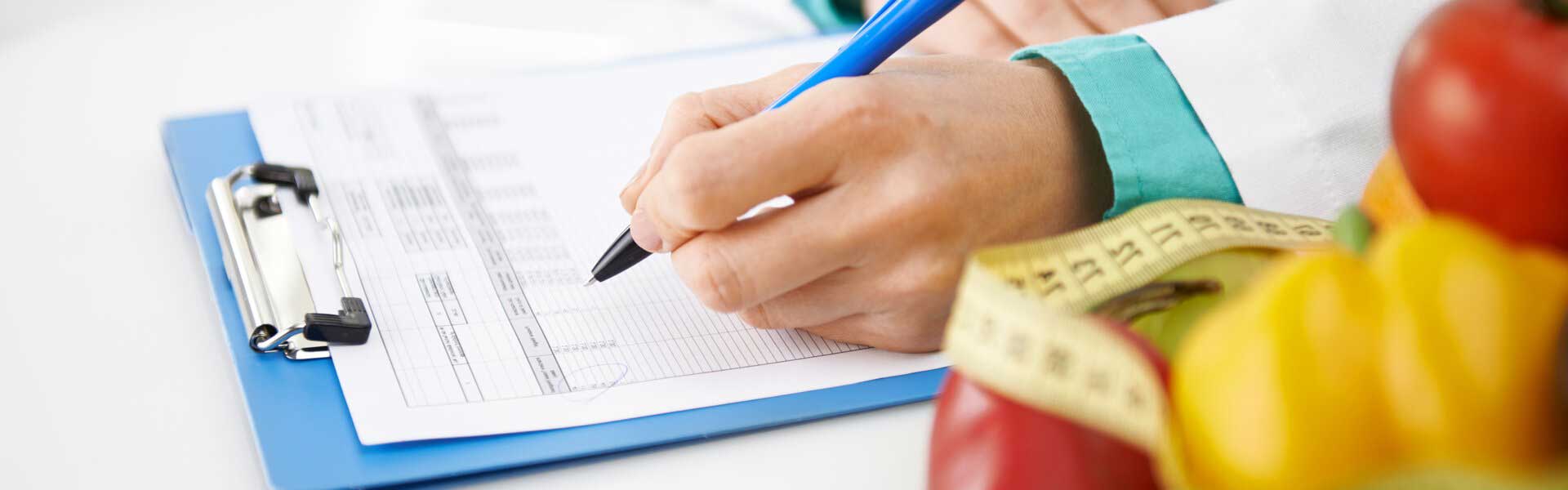 Nutritionist writing on clipboard