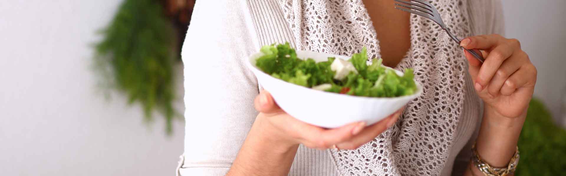 woman holding a salad bowl and fork