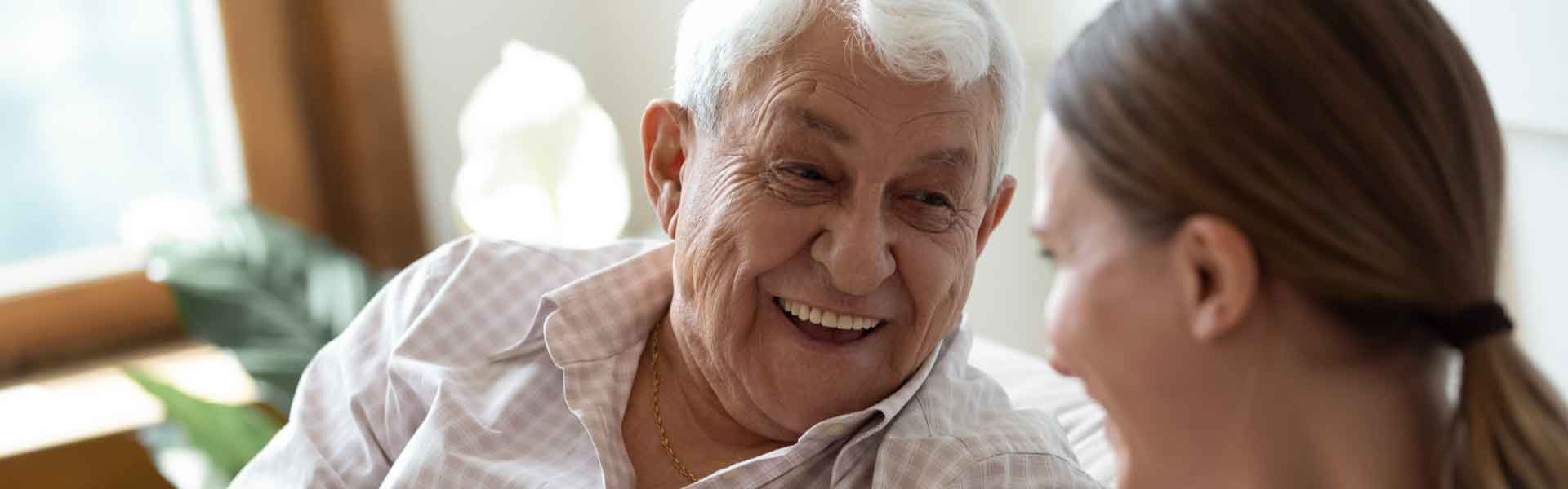 Elderly man talking to younger woman