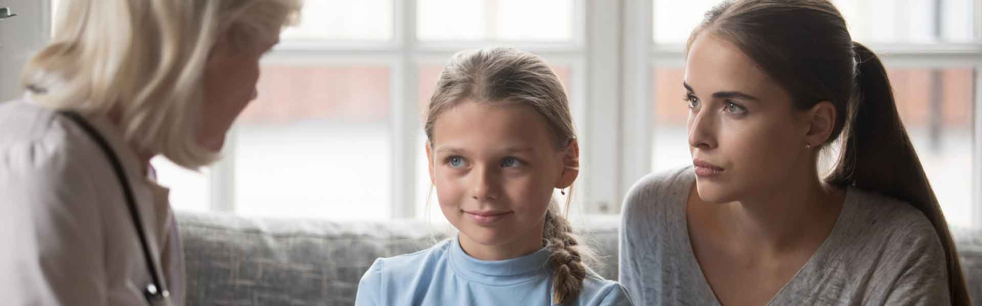 Girl and woman talking to doctor