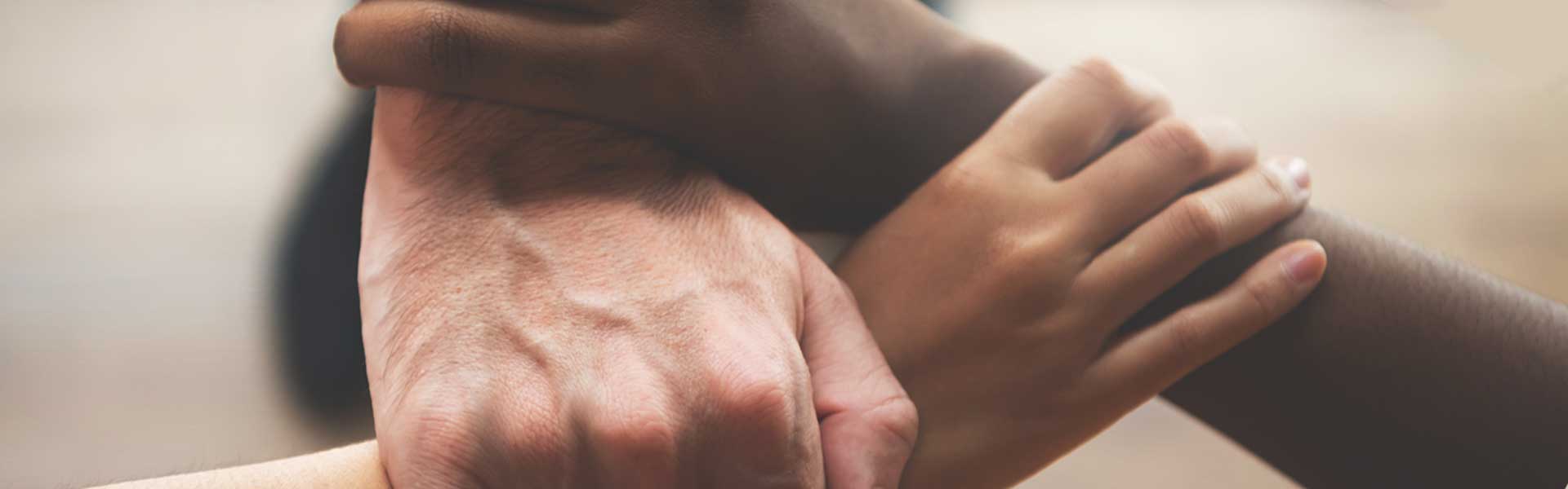 Three hands grasping each other's wrist