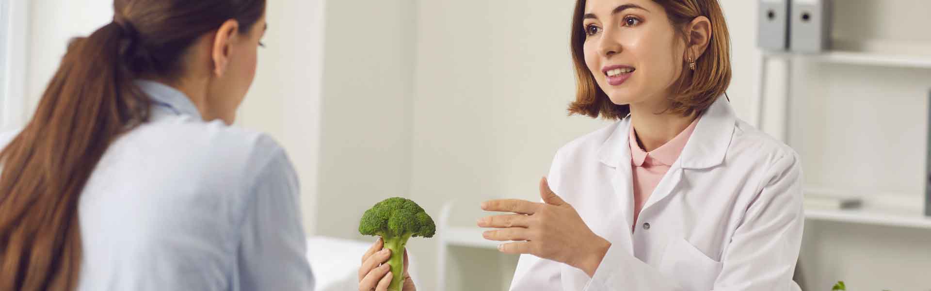 Healthcare professional discussing broccoli with a patient