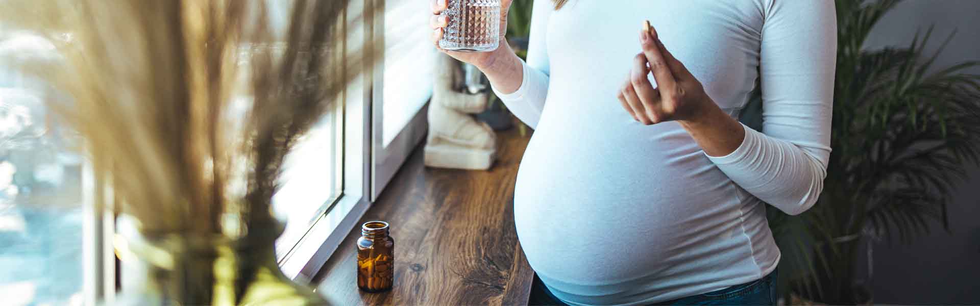 Pregnant woman about to take a pill