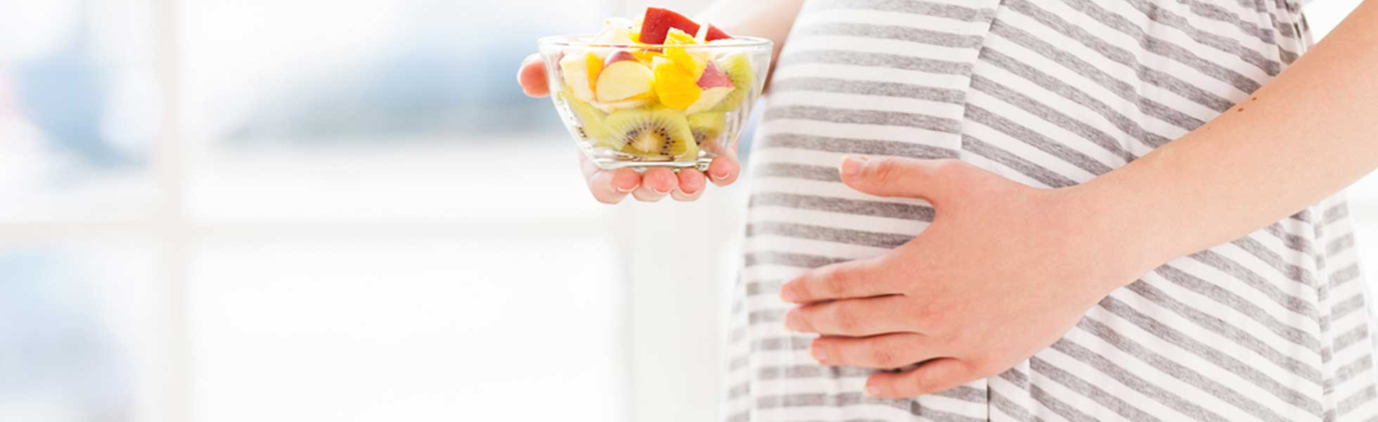 Pregnant woman holding fruit