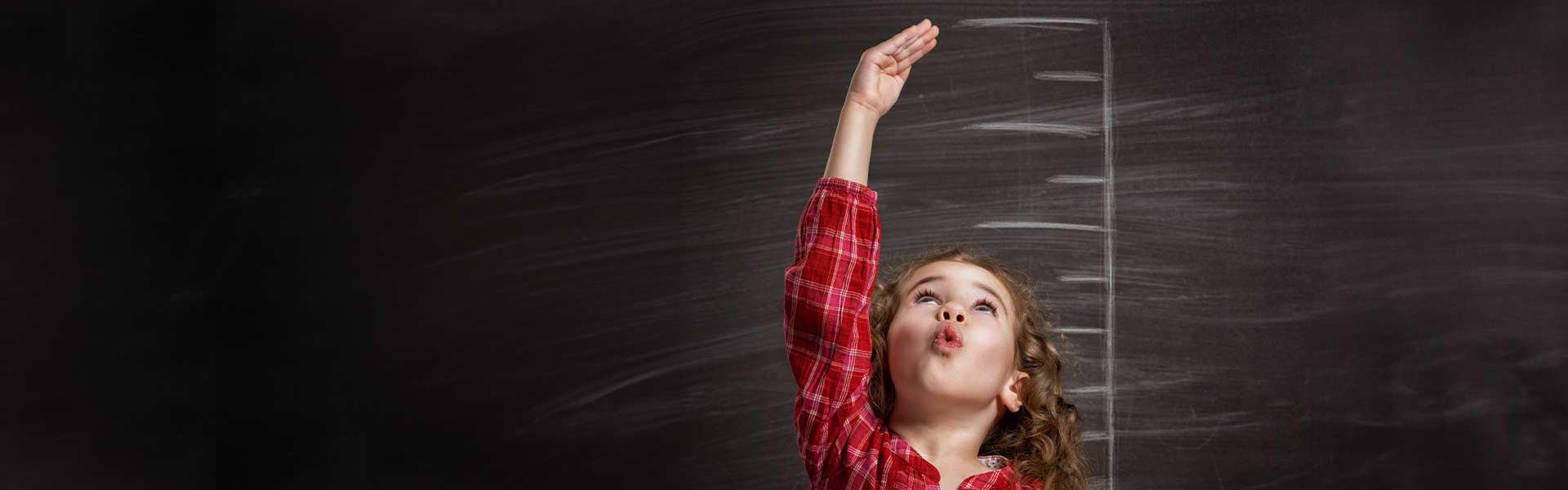 Girl stood in front of a blackboard