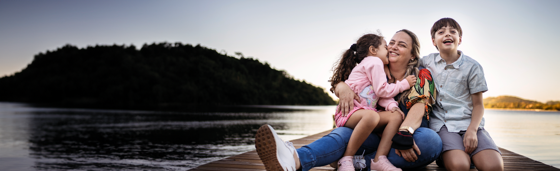 family sat on the pier by the lake 