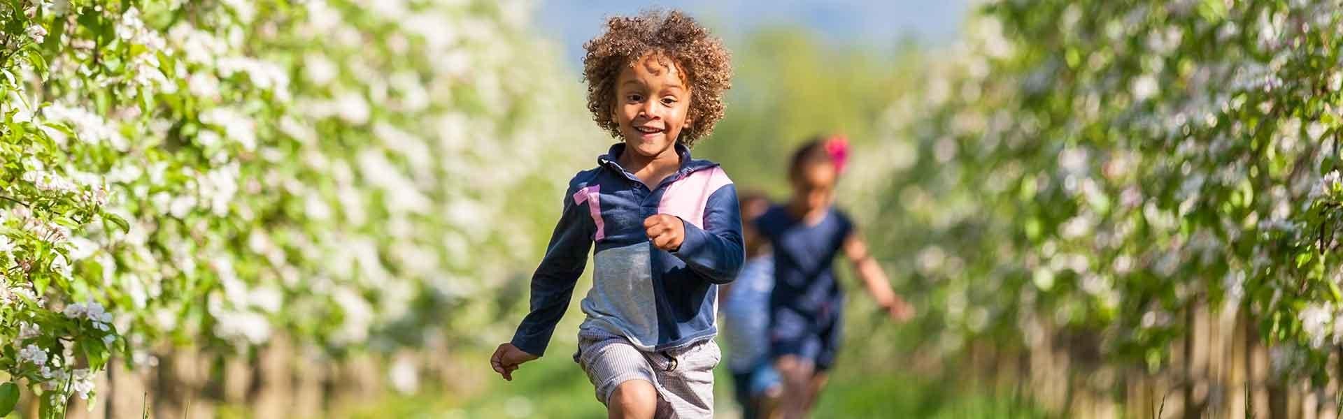 Boy running in an orchard