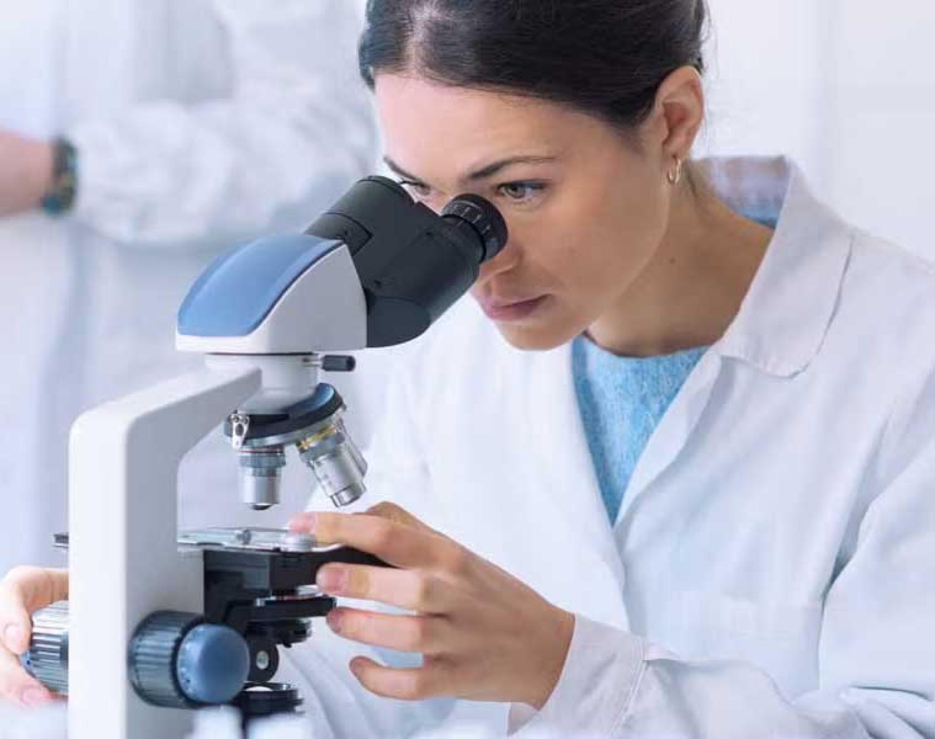 healthcare professional looking at a slide in a microsope