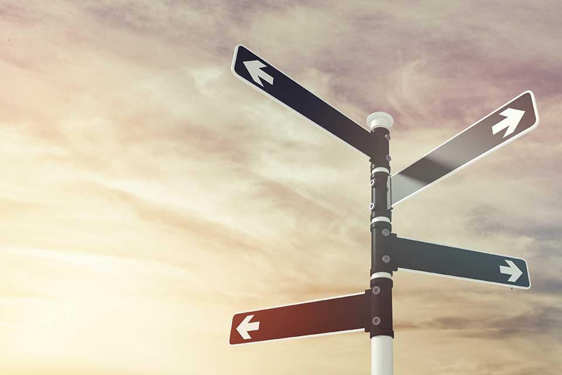 Black signpost with white arrows pointing in different directions