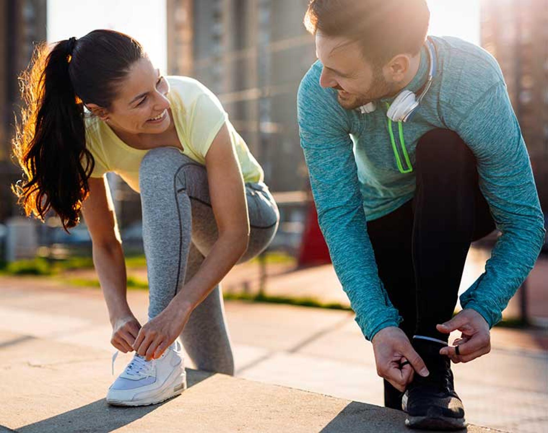 Man and women wearing running clothes tying shoelaces