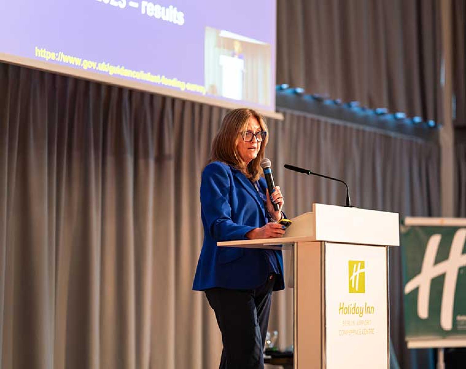 Dr. Julie Lanigan speaking from a platform