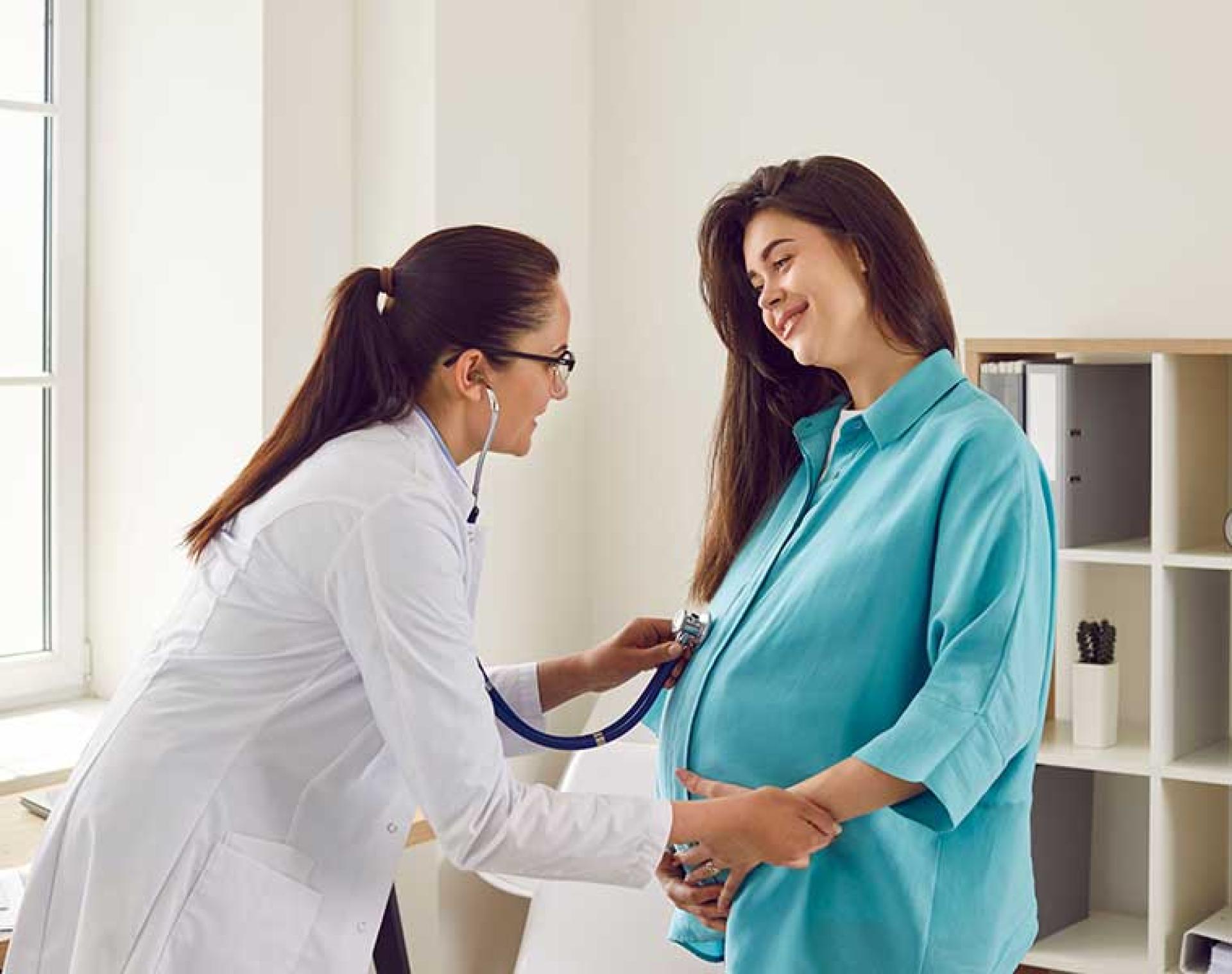 Smiling pregnant woman with healthcare professional