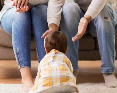 un tout-petit rampant vers ses parents