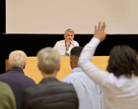 relatore sanitario sul palco che risponde a una domanda del pubblico