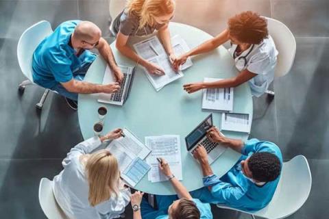 Group of healthcare professionals sitting around a round table